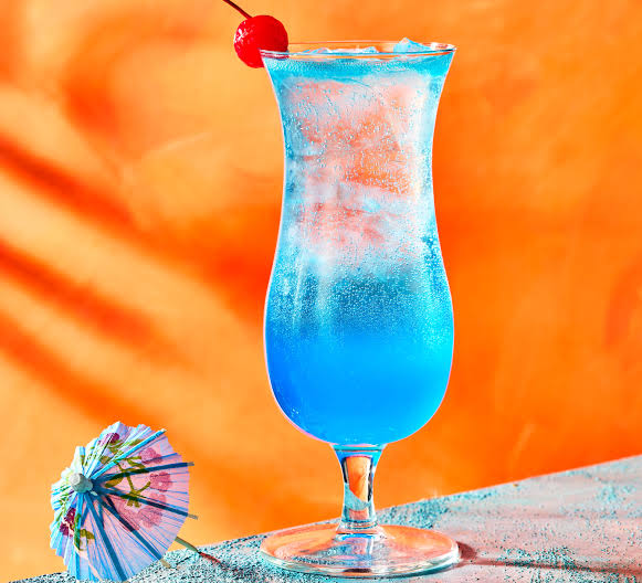 A vibrant blue lagoon cocktail in a tall glass